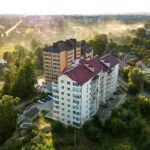 Aerial view of multistory apartment buildings in green residential area.